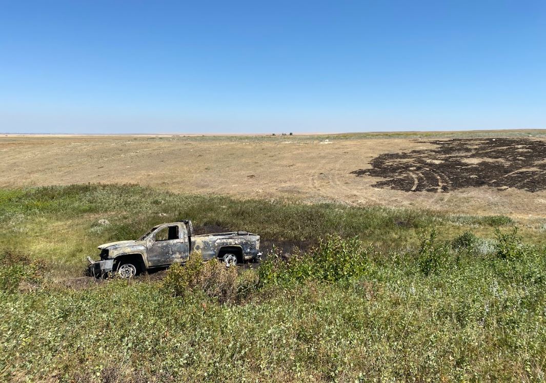 A burnt truck sits in a field on the Blood Tribe.