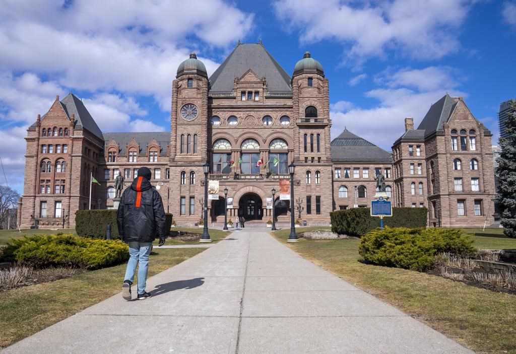 A man walks in front of Queen’s Park in Toronto, Monday, Feb. 20, 2023.
