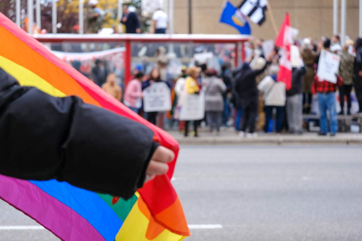 A Pride flag being held across the street from the Million March 4 Children rally in Calgary, Alta. on Wednesday, September 20, 2023.