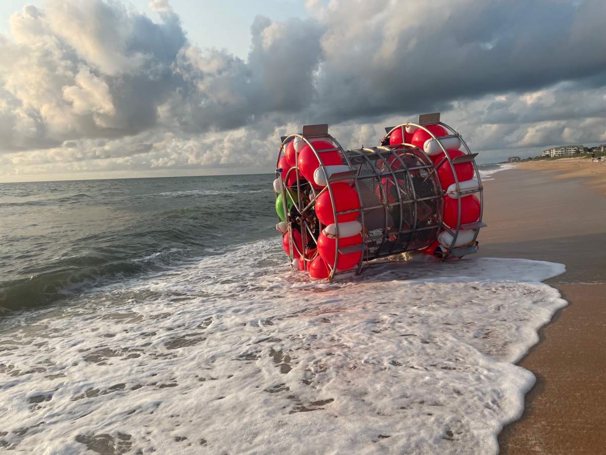 A human-sized, buoyant hamster wheel washed up on the beach.