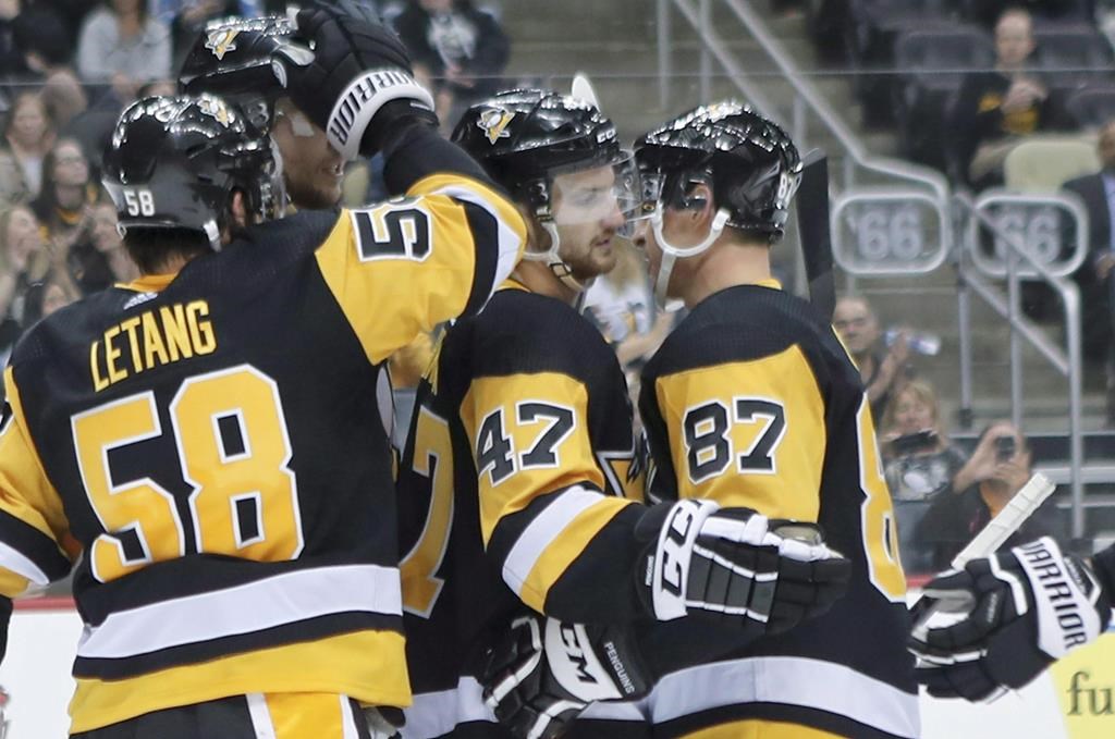 Pittsburgh Penguins’ Adam Johnson (47) celebrates with Sidney Crosby (87) and Kris Letang (58) after scoring against the Columbus Blue Jackets during the second period of an NHL preseason hockey game, Saturday, Sept. 22, 2018, in Pittsburgh. Members of the Winnipeg Jets expressed their support for Adam Johnson, a former NHL player who suffered a serious injury while playing professionally in England on Saturday, leading to the game being abandoned.