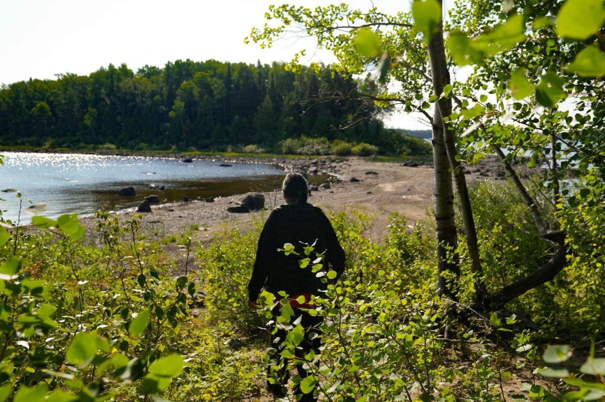 Elder Alex Moonias walks through the land at Landsdowne House, the former home of Neskantaga First Nation, Sunday, Aug. 20, 2023. 