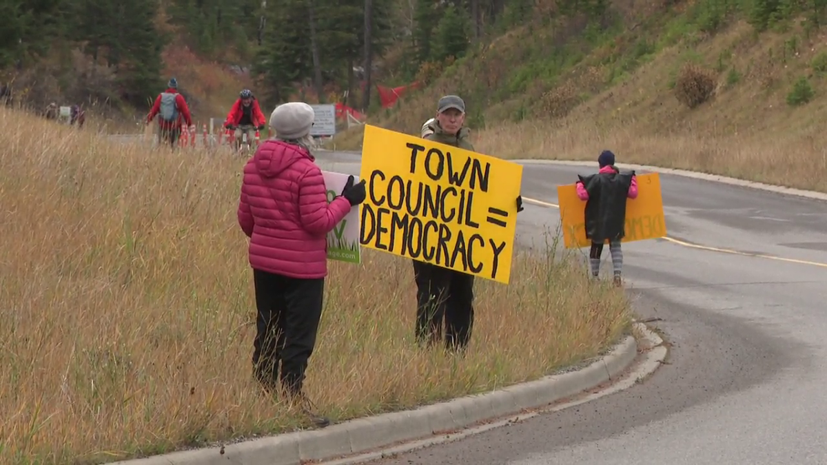 Protesters lined the road in Canmore as the premier drove up to the Silvertip Resort to meet with area developers on Oct. 12, 2023.