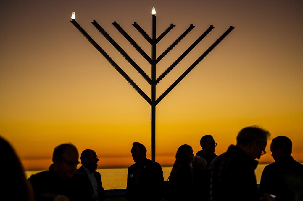 FILE – People gather around the 10-foot menorah during the “Hanukkah on the Pier” event at the end of the San Clemente pier hosted by Chabad of San Clemente in San Clemente, Calif., Sunday, Dec. 18, 2022. (Leonard Ortiz/The Orange County Register via AP, File)