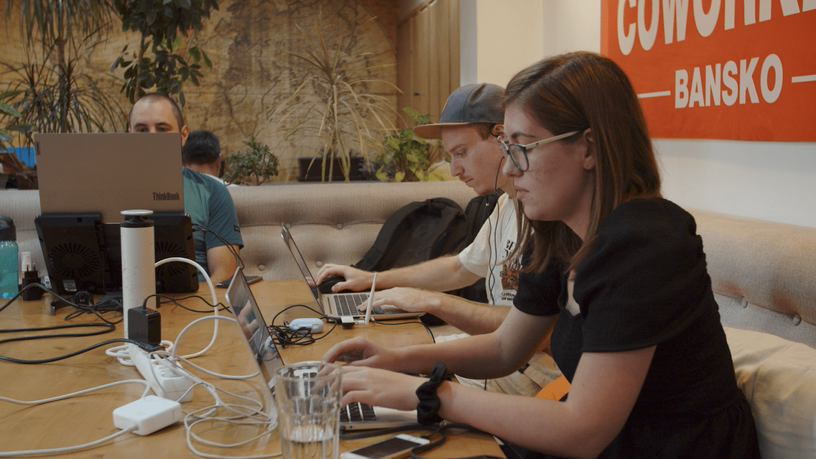 Several digital nomads working on their laptops in Coworking Bansko's lounge space.