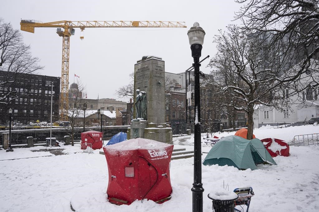 Red ice fishing enclosures are pictured at a tent encampment at Grand Parade in Halifax, Monday, Dec. 4, 2023.