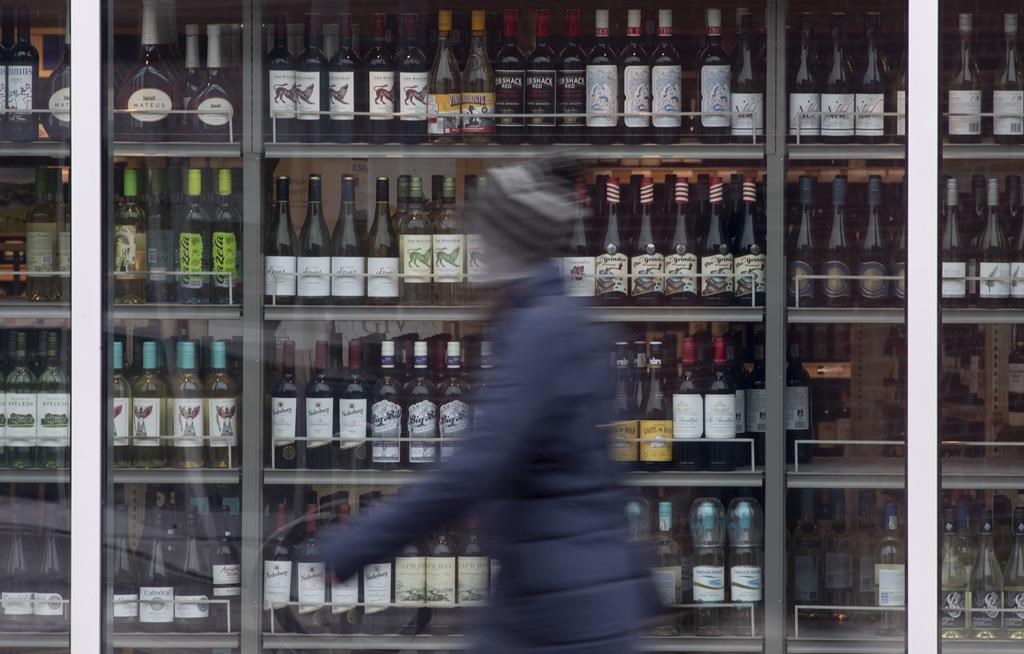 A person walks past shelves of bottles of alcohol on display at an LCBO in Ottawa, Thursday March 19, 2020.