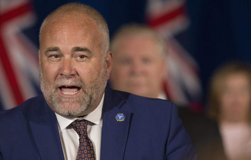 Ontario's energy minister says he will introduce legislation to reverse an Ontario Energy Board decision that would see increased costs for buyers of new homes heated with natural gas. Todd Smith, then-Minister of Children, Community and Social Services, speaks at the microphone at the Queen's Park daily COVID-19 briefing in Toronto on Thursday, June 4, 2020.