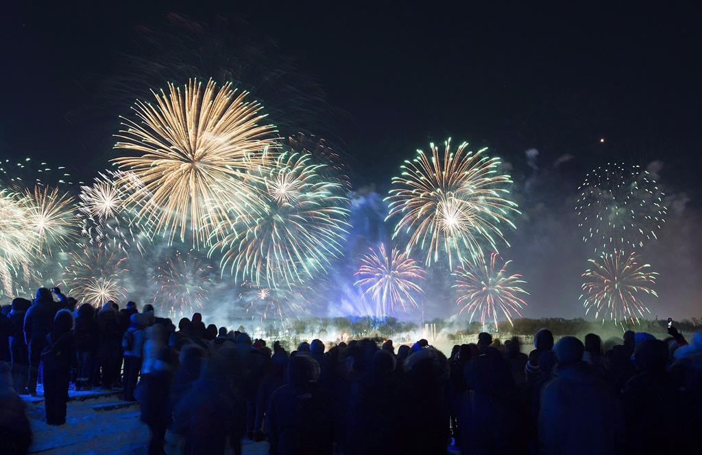 People look on as fireworks explode over Montreal’s Old Port during New Years Eve celebrations. There will be no midnight fireworks to herald the new year in Montreal’s Old Port.