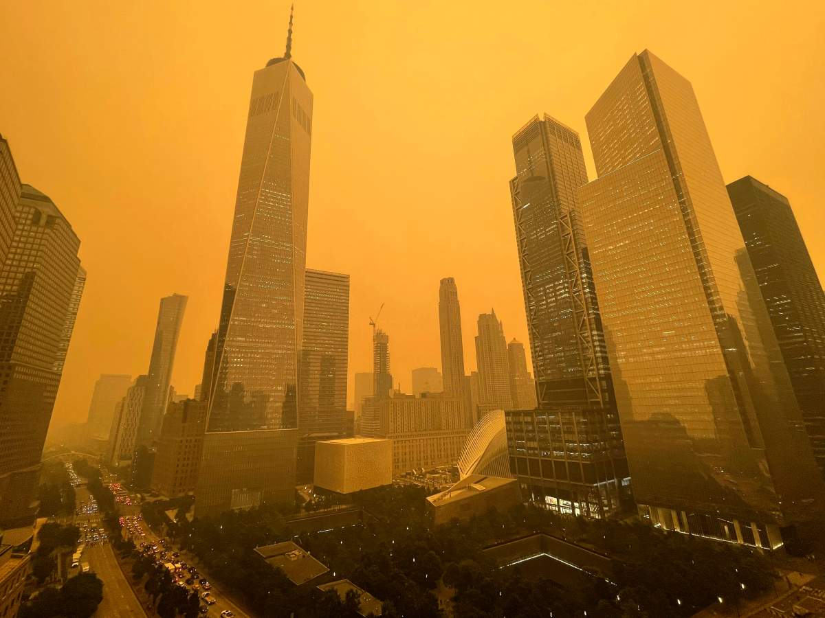 Traffic moves along West Street past One World Trade Center, Wednesday, June 7, 2023, in New York, amidst smokey haze from wildfires in Canada. Smoke from Canadian wildfires poured into the U.S. East Coast and Midwest on Wednesday, covering the capitals of both nations in an unhealthy haze, holding up flights at major airports and prompting people to fish out pandemic-era face masks. (AP Photo/Andy Bao)