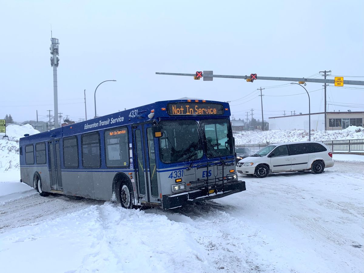 A city bus is seen in the area of 127th Street and 127th Avenue in Edmonton on Monday morning. The bus was struggling to move after a heavy snowfall and a tow truck was called to the area.
