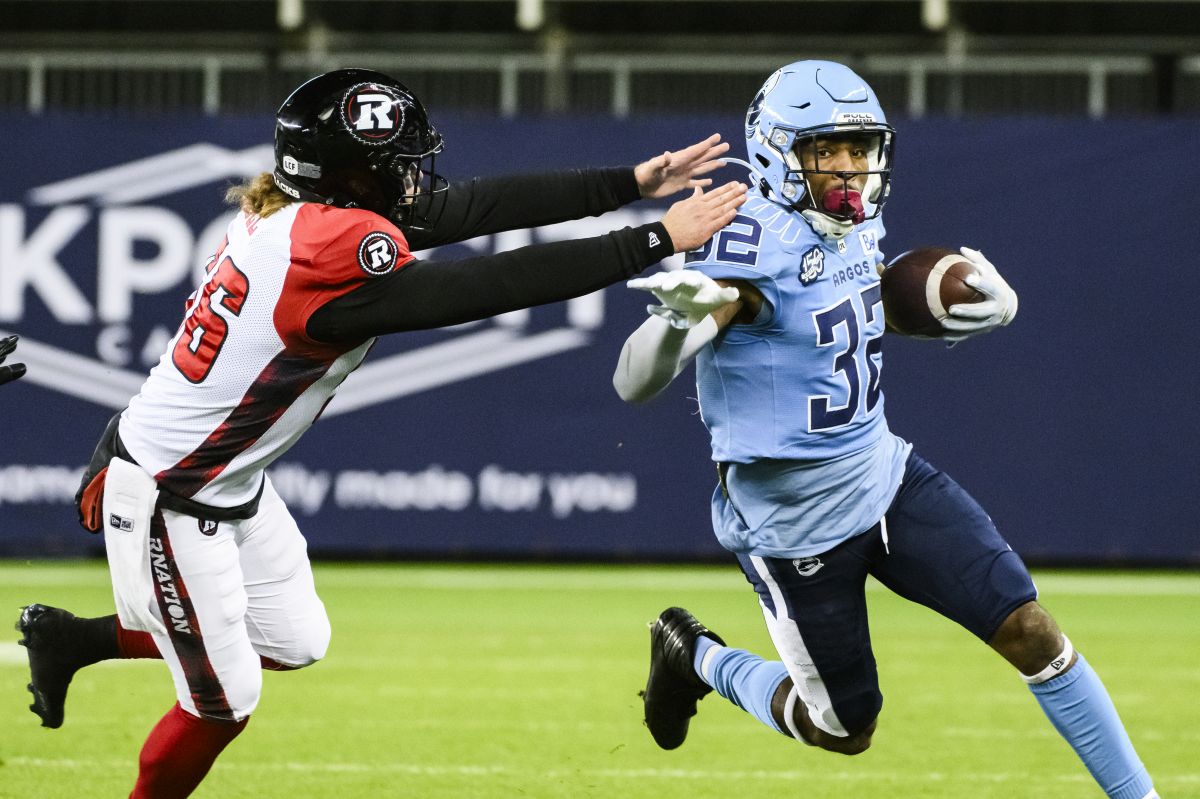 Toronto Argonauts running back Javon Leake (32) returns the ball while Ottawa Redblacks long snapper Tanner Doll (56) attempts to make the tackle, during first half CFL action, in Toronto, Saturday, Oct. 14, 2023.