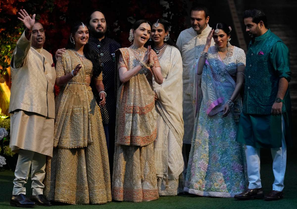 Several people stand together in traditional Indian attire.
