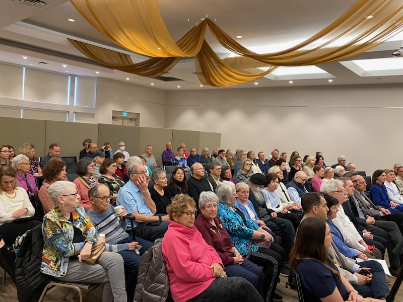 A large crowd of people sitting in a room.