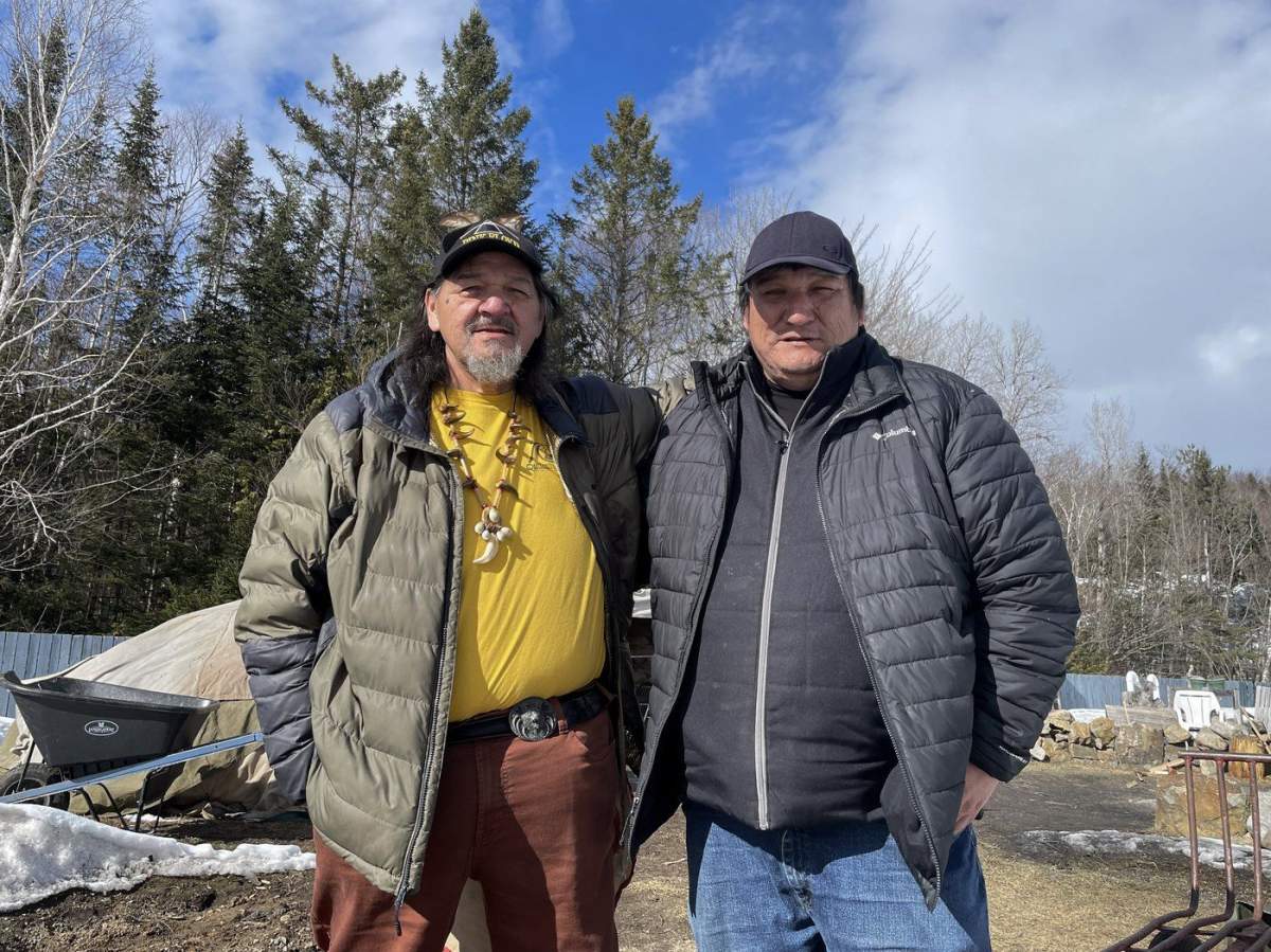Grégoire and Michael Canapé stand near the cooling rocks of the sweat ceremony lodge at Waseskun Healing Centre, an Indigenous-run facility that is is the equivalent of a minimum-security penitentiary, in Saint-Alphonse-Rodriguez, Que., on March 20, 2024. The brothers are members of the Midewiwin Society of religious elders, healers and spiritual advisers.`