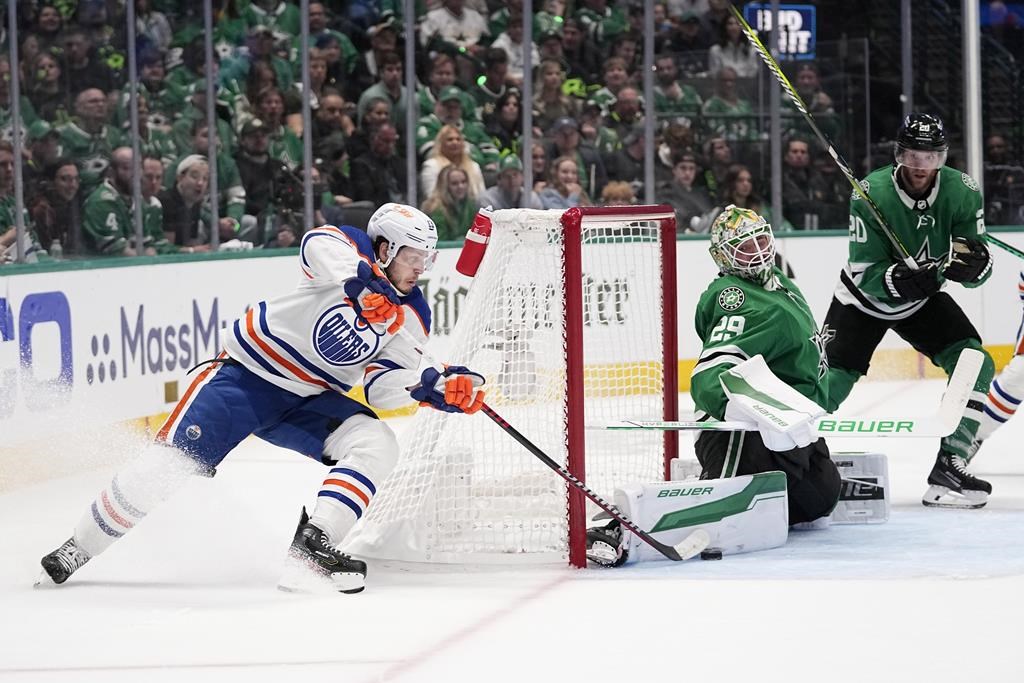 Dallas Stars goaltender Jake Oettinger (29) blocks a shot by Edmonton Oilers centre Mattias Janmark, left, as Stars' Ryan Suter (20) looks on during the second period in Game 2 of the Western Conference finals in the NHL hockey Stanley Cup playoffs Saturday, May 25, 2024, in Dallas.