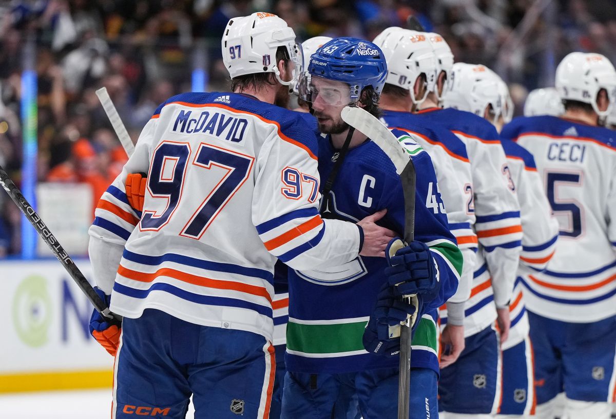 Vancouver Canucks' Quinn Hughes, front right, and Edmonton Oilers' Connor McDavid talk while shaking hands after Edmonton defeated Vancouver during Game 7 of an NHL hockey Stanley Cup second-round playoff series, in Vancouver, on Monday, May 20, 2024.