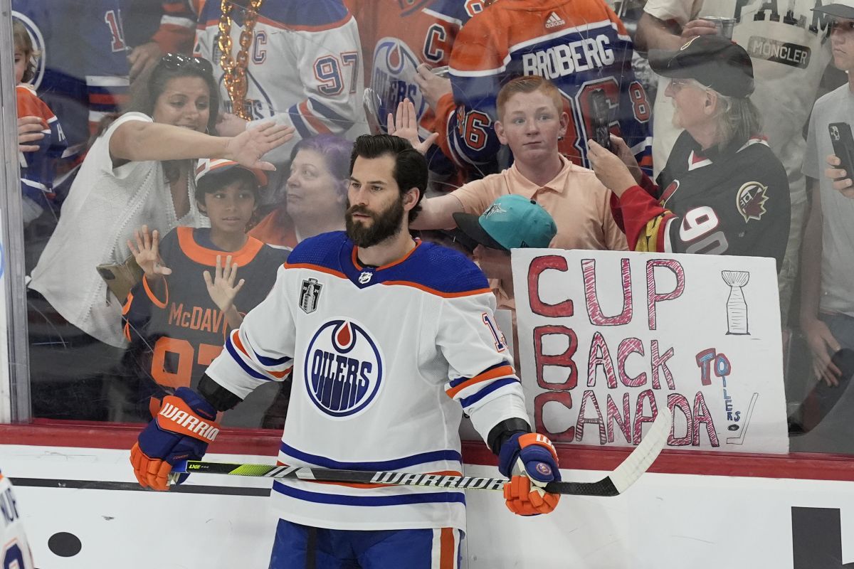 Fans try to get the attention of Edmonton Oilers center Adam Henrique before Game 7 of the NHL hockey Stanley Cup Final against the Florida Panthers, Monday, June 24, 2024, in Sunrise, Fla.