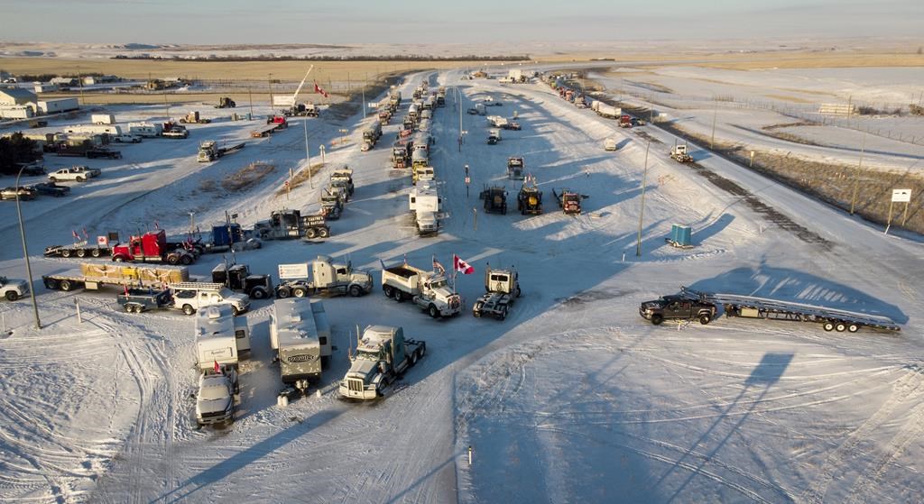 A truck convoy of anti-COVID-19 vaccine mandate demonstrators block the highway at the busy U.S. border crossing in Coutts, Alta., on February 2, 2022.