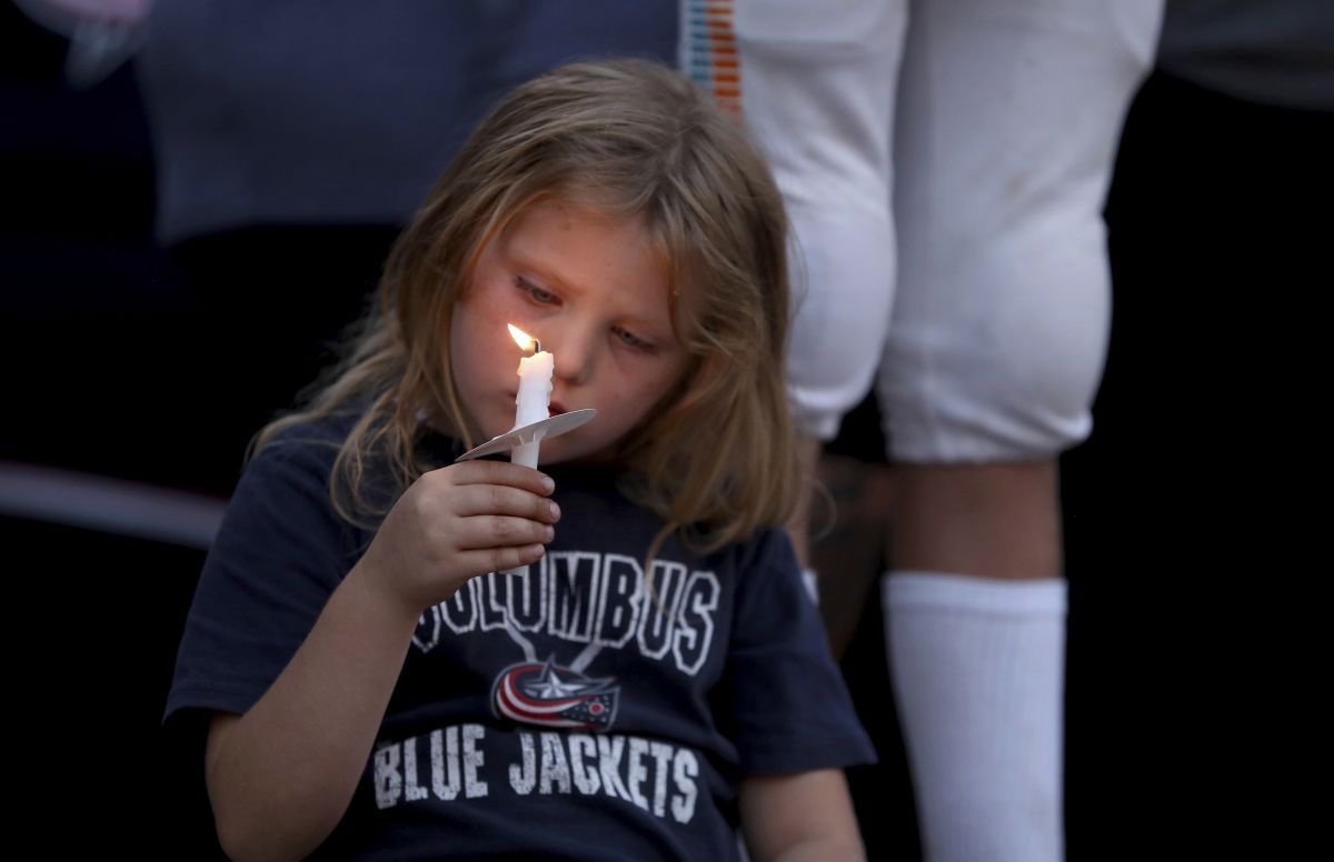 Columbus Blue Jackets fan Scarlett Well, has a moment of silence during the candlelight vigil to honour of Blue Jackets hockey player Johnny Gaudreau, outside of Nationwide Arena in Columbus, Ohio, Wednesday, Sept. 4, 2024. Gaudreau and his brother Matthew were killed by a motor vehicle last week while riding bicycles.