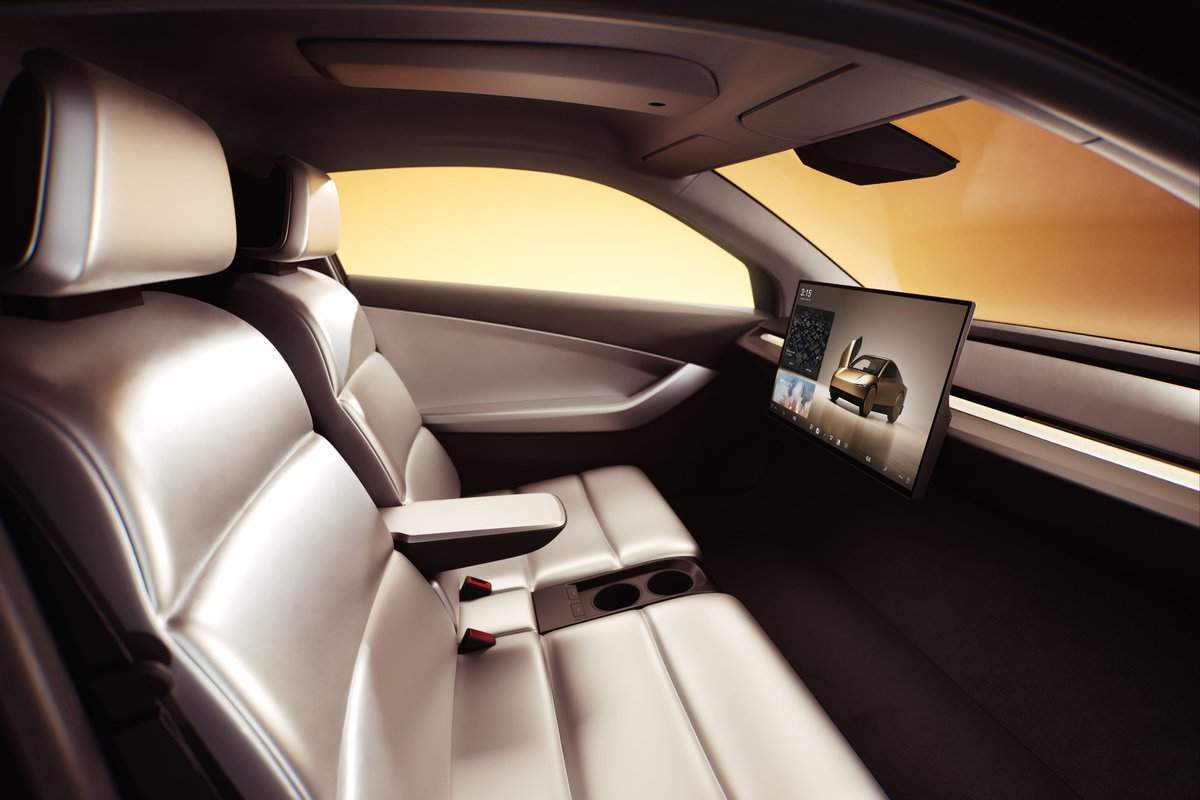Two seats and a screen are seen inside a Cybercab. There is no steering wheel.