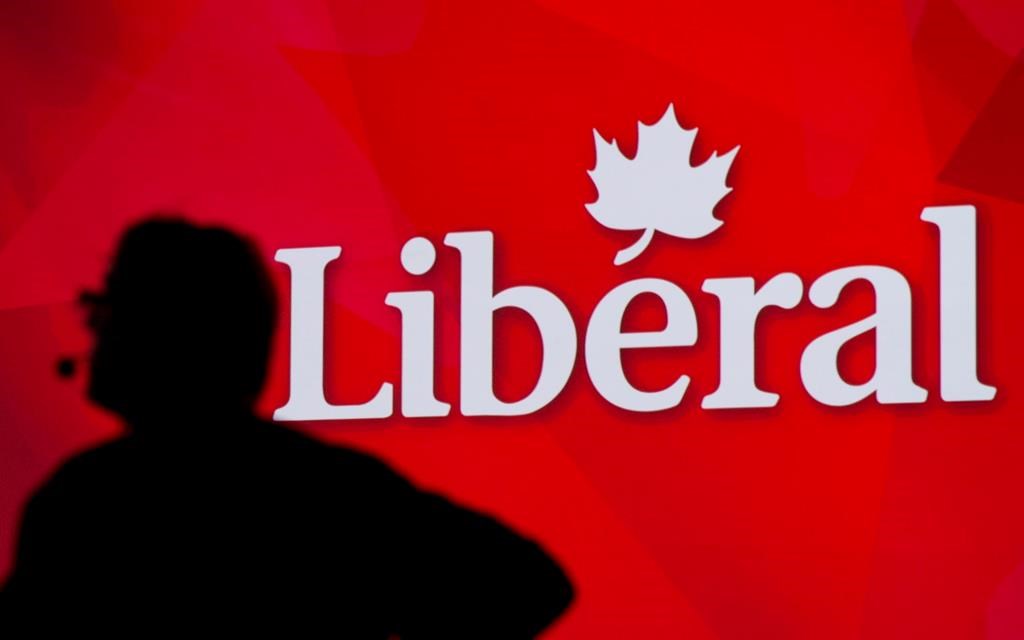 A Liberal Party of Canada logo is shown on a giant screen as a technician looks on during day one of the party's biennial convention in Montreal on Feb. 20, 2014.