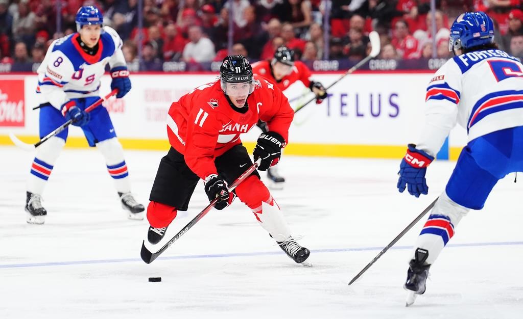 Canada's Brayden Yager (11) skates with the puck as USA's Drew Fortescue (5) defends during second period IIHF World Junior Hockey Championship tournament action in Ottawa on Tuesday, Dec. 31, 2024. THE CANADIAN PRESS/Sean Kilpatrick.