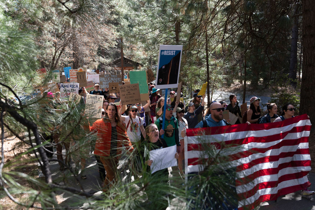 Protesters hold signs at Roosevelt Arch, the northern entrance to Yellowstone Park on March 1, 2025 in Gardiner, Montana. About 200 people showed up at the rally to protest recent firings of the National Park Service and National Forest Service Staff. Similar protests were held at many other national parks throughout the United States.