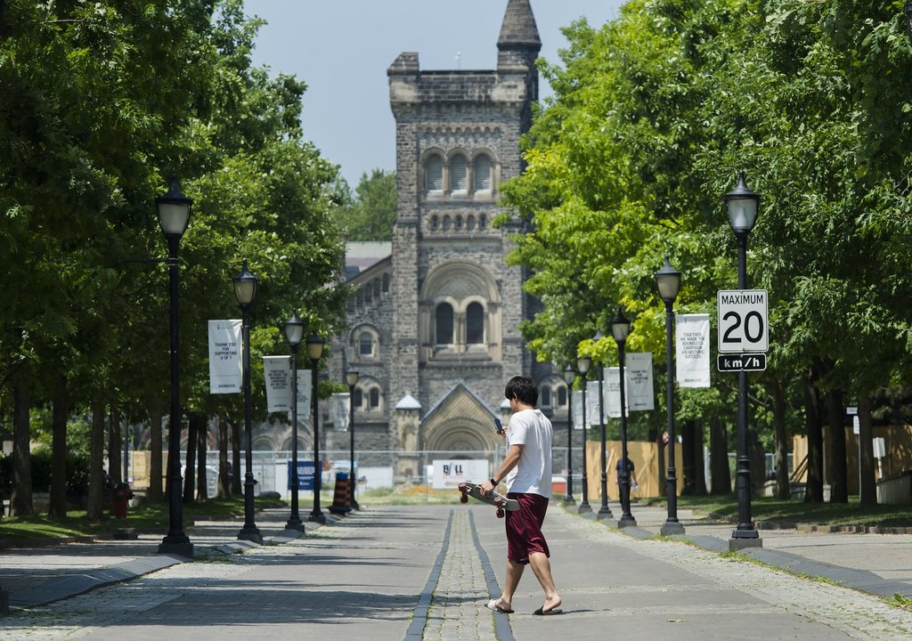 A person walks past the University of Toronto campus in Toronto, Wednesday, June 10, 2020. The University of Toronto is launching a new climate institute with the help of a $60 million gift. THE CANADIAN PRESS/Nathan Denette.