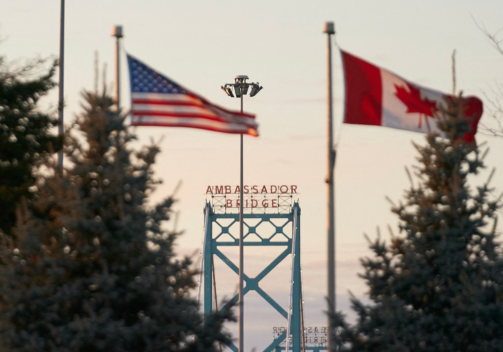 A file photo of Canadian and American flags fly on the Canadian side of the Ambassador Bridge in Windsor, Ontario, on March 8, 2025.