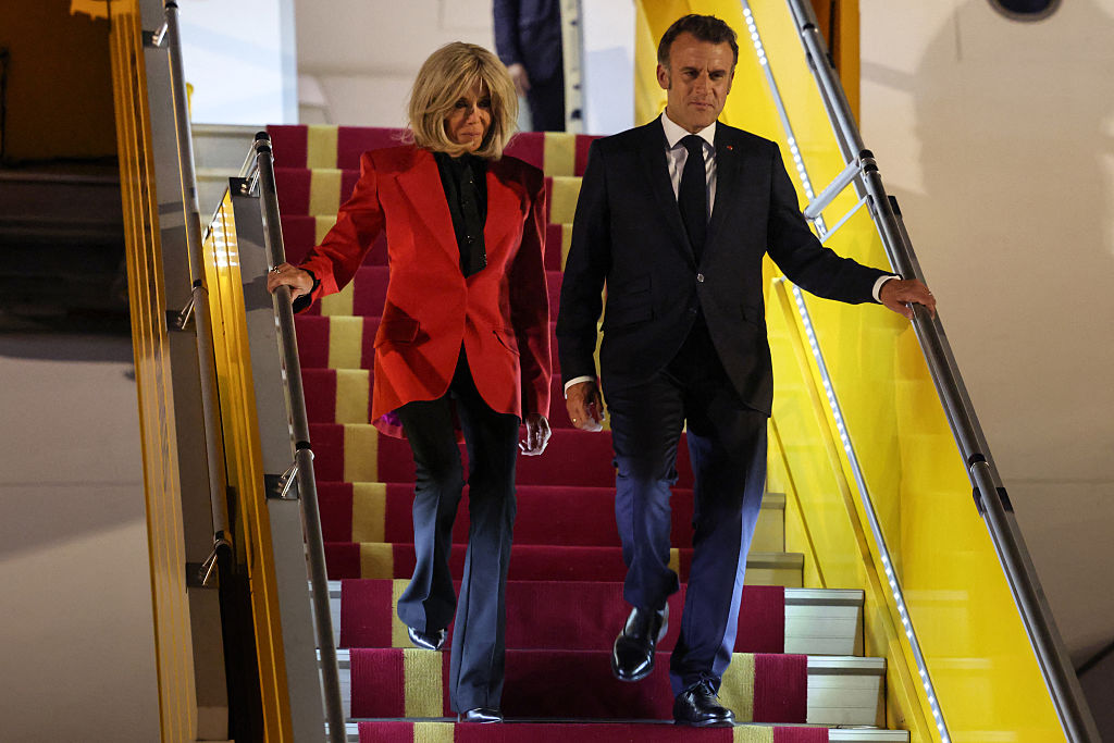 France's President Emmanuel Macron and his wife Brigitte Macron disembark from the plane upon their arrival at Noi Bai International Airport in Hanoi on May 25, 2025.