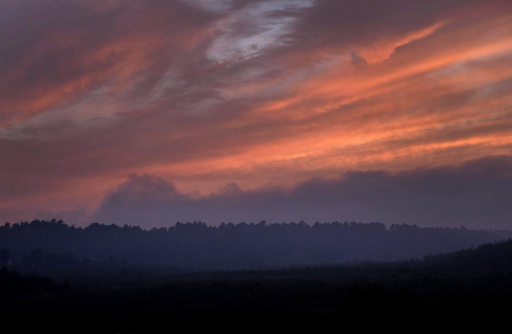 Smoke hangs above the treeline near dusk blocking out the setting sun near Killarney, Ont.