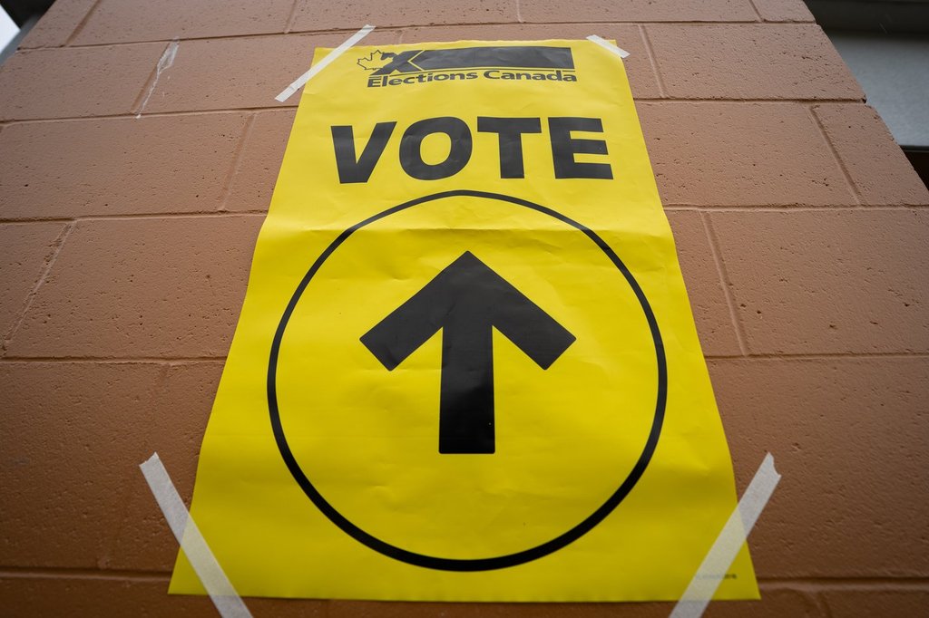 A vote sign is taped to the wall at a polling station on federal election day in Vancouver, on Monday, April 28, 2025. 