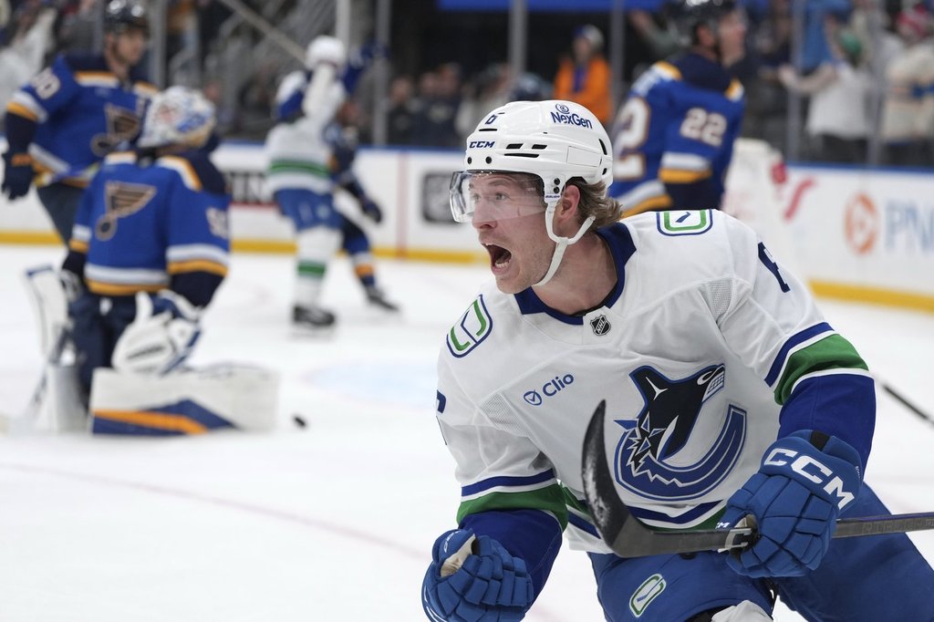 FILE - Vancouver Canucks' Brock Boeser, right, celebrates after scoring past St. Louis Blues goaltender Jordan Binnington, left, during the third period of an NHL hockey game, March 20, 2025, in St. Louis. 