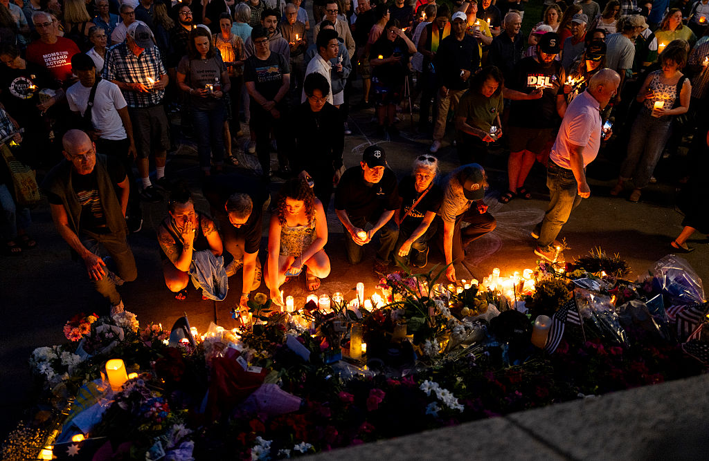 People lay down their candles at a memorial on the steps outside the Minnesota State Capitol building during a candlelight vigil on June 18, 2025 in St. Paul, Minnesota.