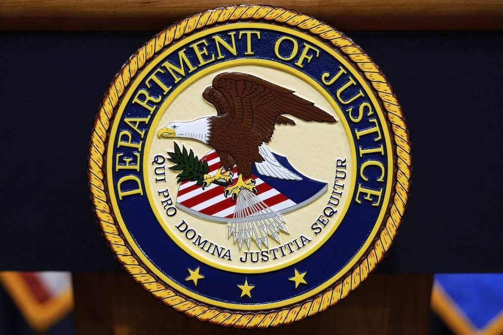 FILE - The U.S. Department of Justice logo is seen on a podium before a press conference with Attorney General Pam Bondi, Tuesday, May 6, 2025, at the Justice Department in Washington. 