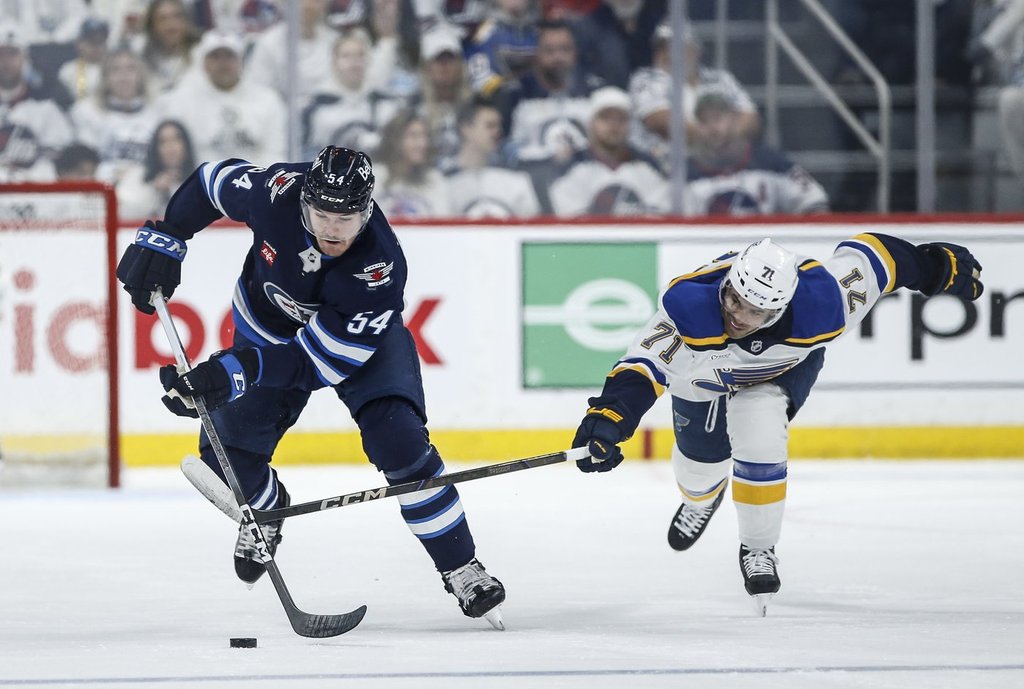Winnipeg Jets' Dylan Samberg (54) breaks away from St. Louis Blues' Mathieu Joseph (71) during second-period NHL playoff action in Winnipeg on Saturday, April 19, 2025. THE CANADIAN PRESS/John Woods.