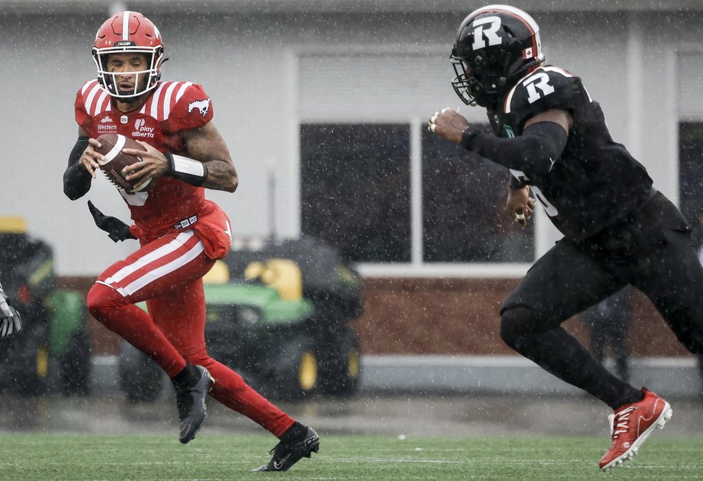 Ottawa Redblacks' Adarius Pickett, right, chases Calgary Stampeders quarterback Vernon Adams during first half CFL football action in Calgary, Saturday, June 21, 2025.