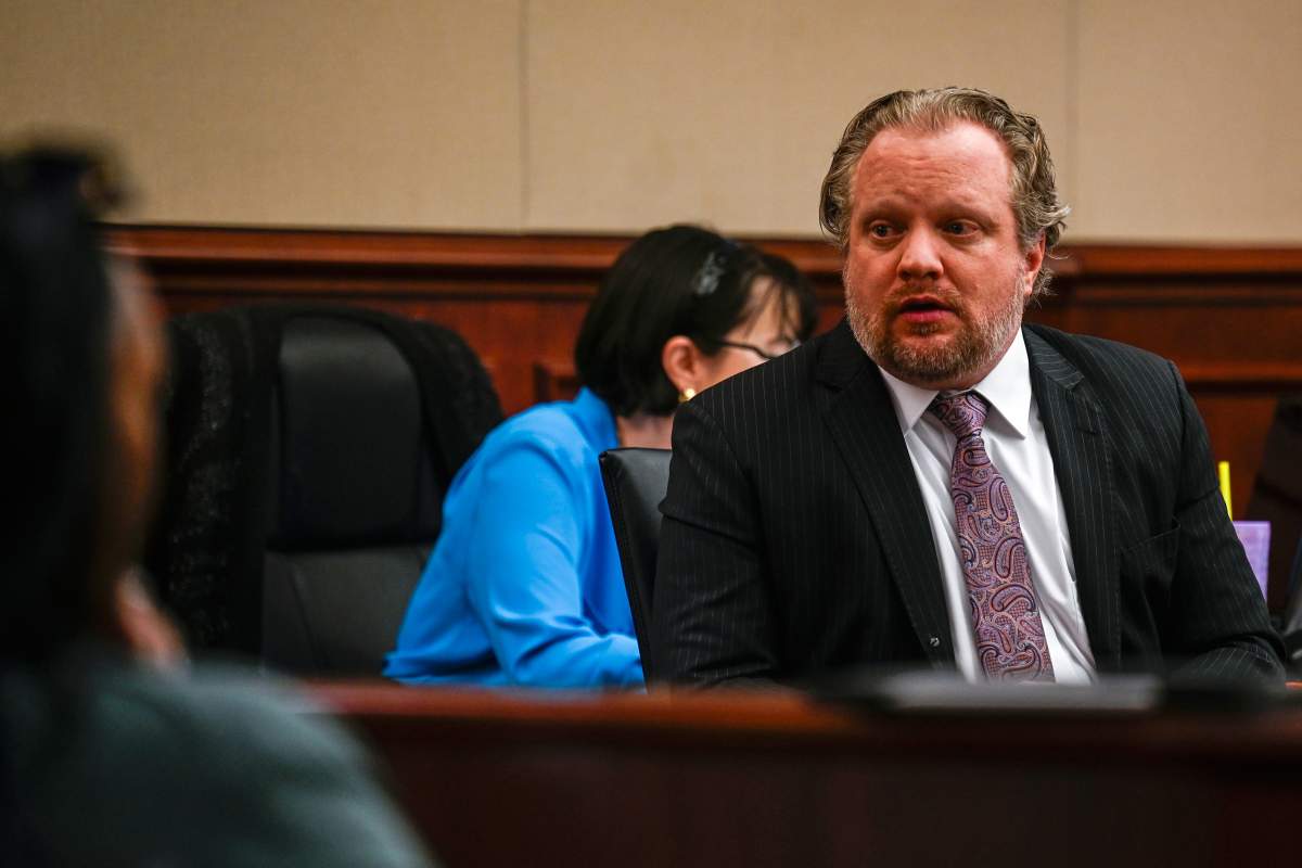 James Craig, who is accused of killing his wife, talks with family members from his seat before opening arguments in his murder trial at the Arapahoe District Court on July 15, 2025, in Centennial, Colo.