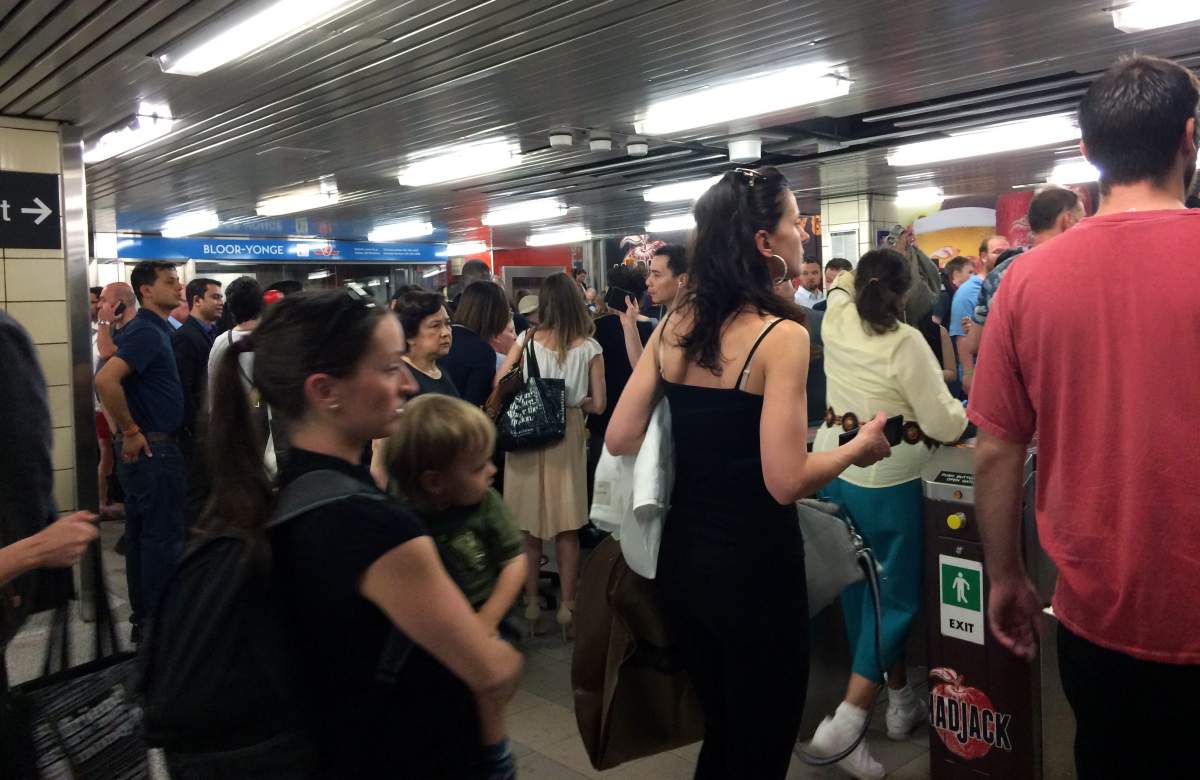 People exit the Bloor-Yonge subway station following the announcement of a service suspension on Line 2 during the evening rush hour, Toronto, Ont., June 22, 2015.  