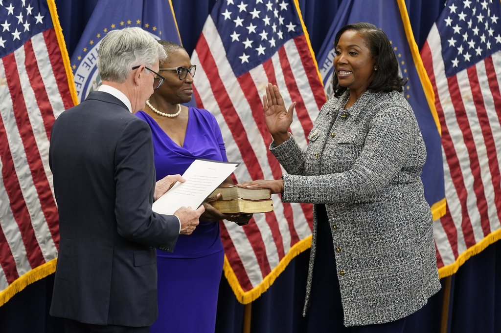FILE - Lisa Cook, right, takes the oath of office to become a member of the Federal Reserve Board, May 23, 2022, in Washington.