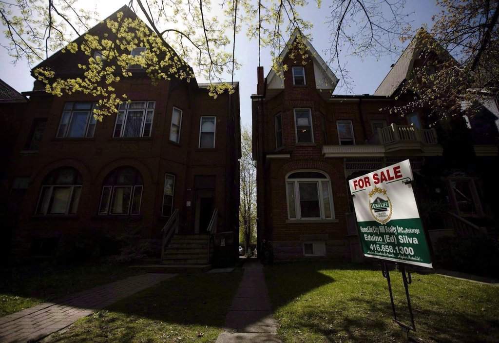 A "For Sale" sign sits in front of a house, in Toronto, on April 20, 2010. THE CANADIAN PRESS/Darren Calabrese.