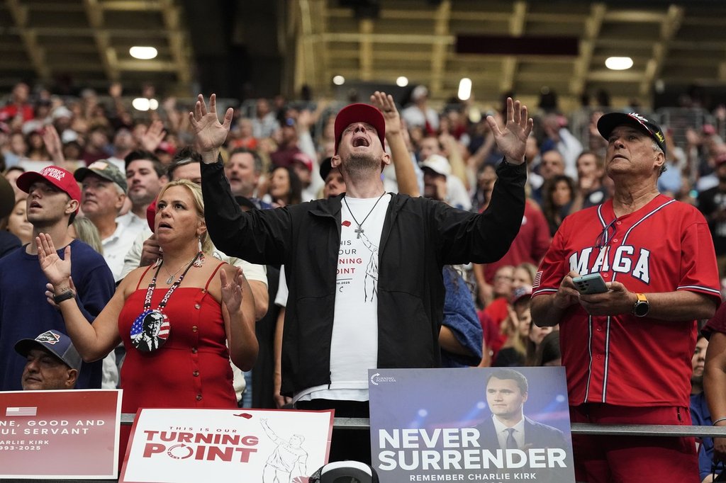 A man listens during a worship song before the start of a memorial for conservative activist Charlie Kirk, Sunday, Sept. 21, 2025, at State Farm Stadium in Glendale, Ariz.