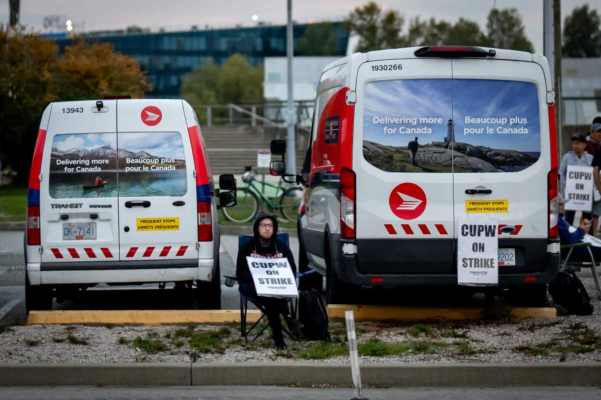 A member of the Canadian Union of Postal Workers pickets outside of a Canada Post Centre in Richmond B.C. on Friday, Sept. 26, 2025.