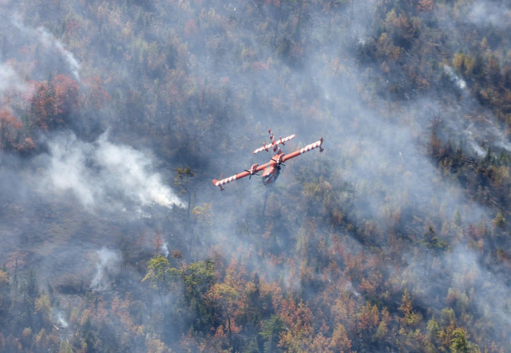 A plane from Newfoundland and Labrador flies over the Lake George wildfire near Aylesford, N.S. in this Friday, Oct. 3, 2025 handout photo. 