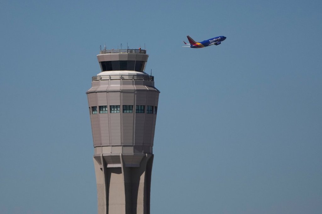 FILE - A plane takes off near the air traffic control tower at Harry Reid International Airport, Tuesday, Oct. 7, 2025, in Las Vegas.