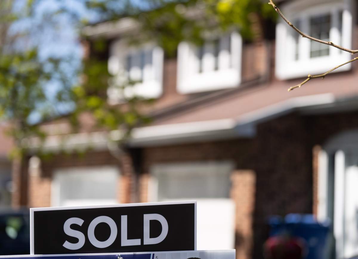 A real estate sign is posted outside a home in Pointe-Claire, a city in Montreal's West Island, Tuesday, May 7, 2024.