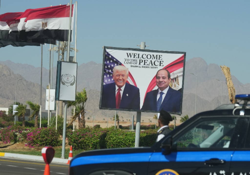 A police vehicle in front of a poster showing Egyptian President Abdel-Fattah el-Sissi and U.S. President Donald Trump at the Red Sea city of Sharm el-Sheikh, Egypt, Monday, Oct. 13, 2025.