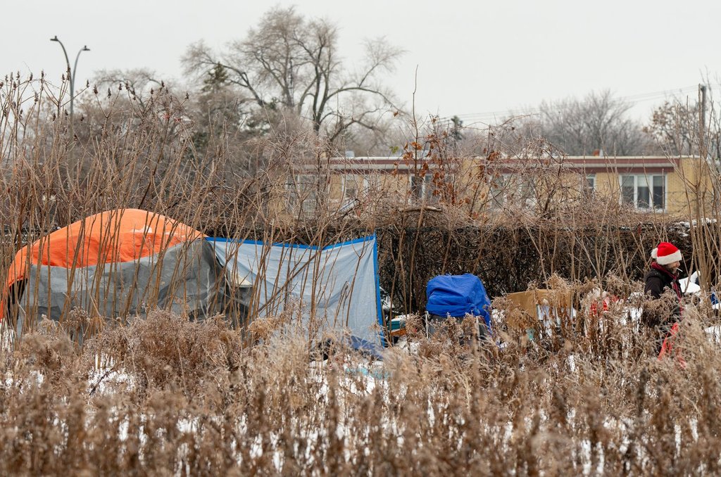 A man walks out of his tent set up off a bike path in the Verdun neighbourhood of Montreal on Tuesday, Dec.10, 2024. THE CANADIAN PRESS/Christinne Muschi.