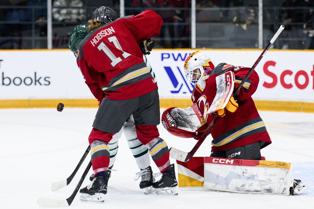 Ottawa Charge goaltender Gwyneth Philips (33) looks for the puck through teammate Brooke Hobson (11) and Boston Fleet’s Theresa Schafzahl (17) during second period PWHL hockey action in Ottawa, on Saturday, Dec. 27, 2025. THE CANADIAN PRESS/Spencer Colby.